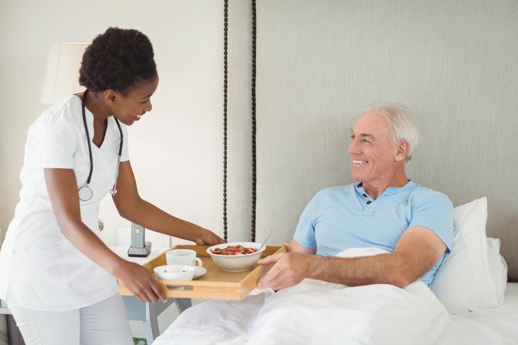 A caregiver bringing breakfast to a client at home